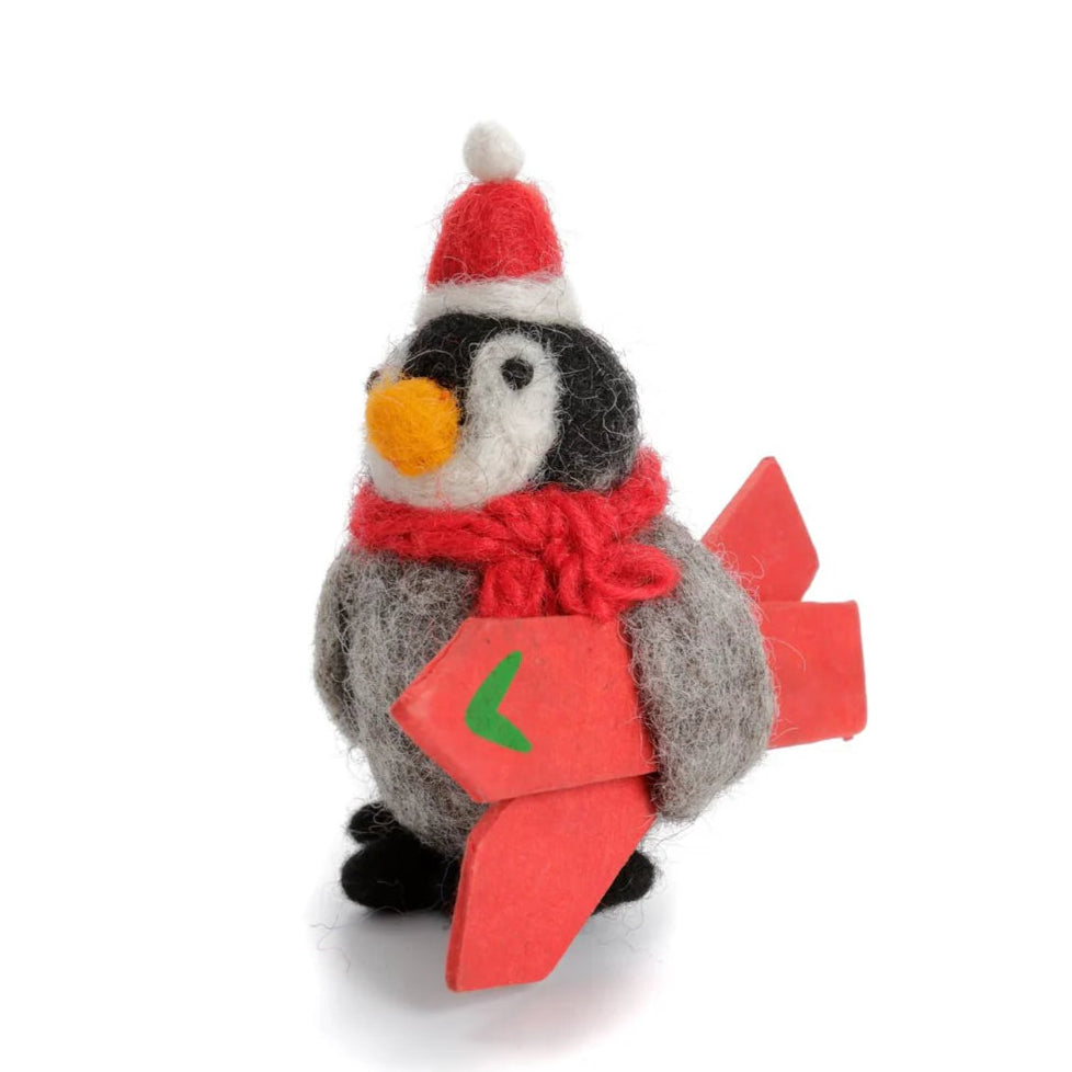 Plush penguin toy wearing a Santa hat and scarf, holding a red box with a green number on a white background.