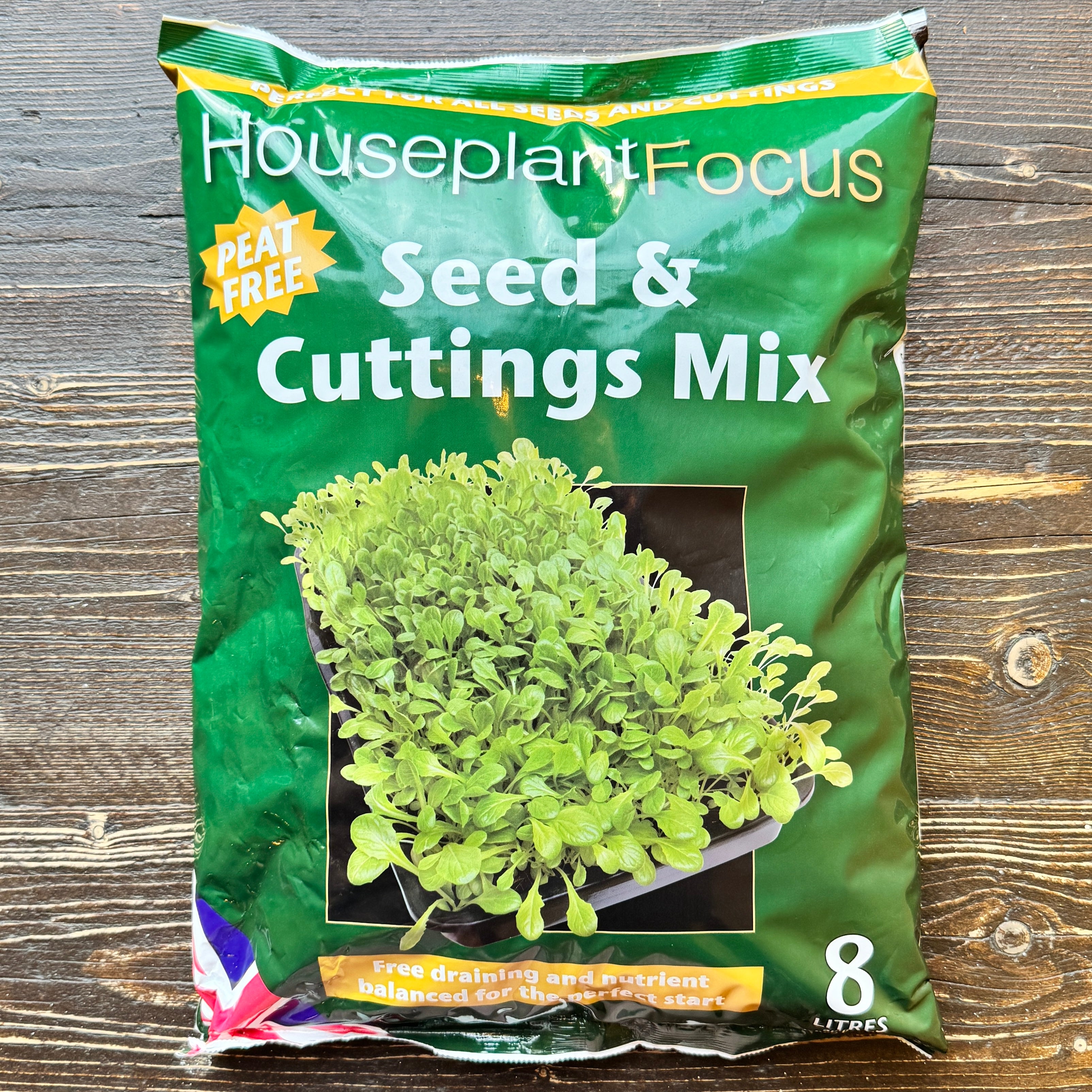 Green bag of Houseplant Focus Seed & Cuttings Mix on a wooden surface