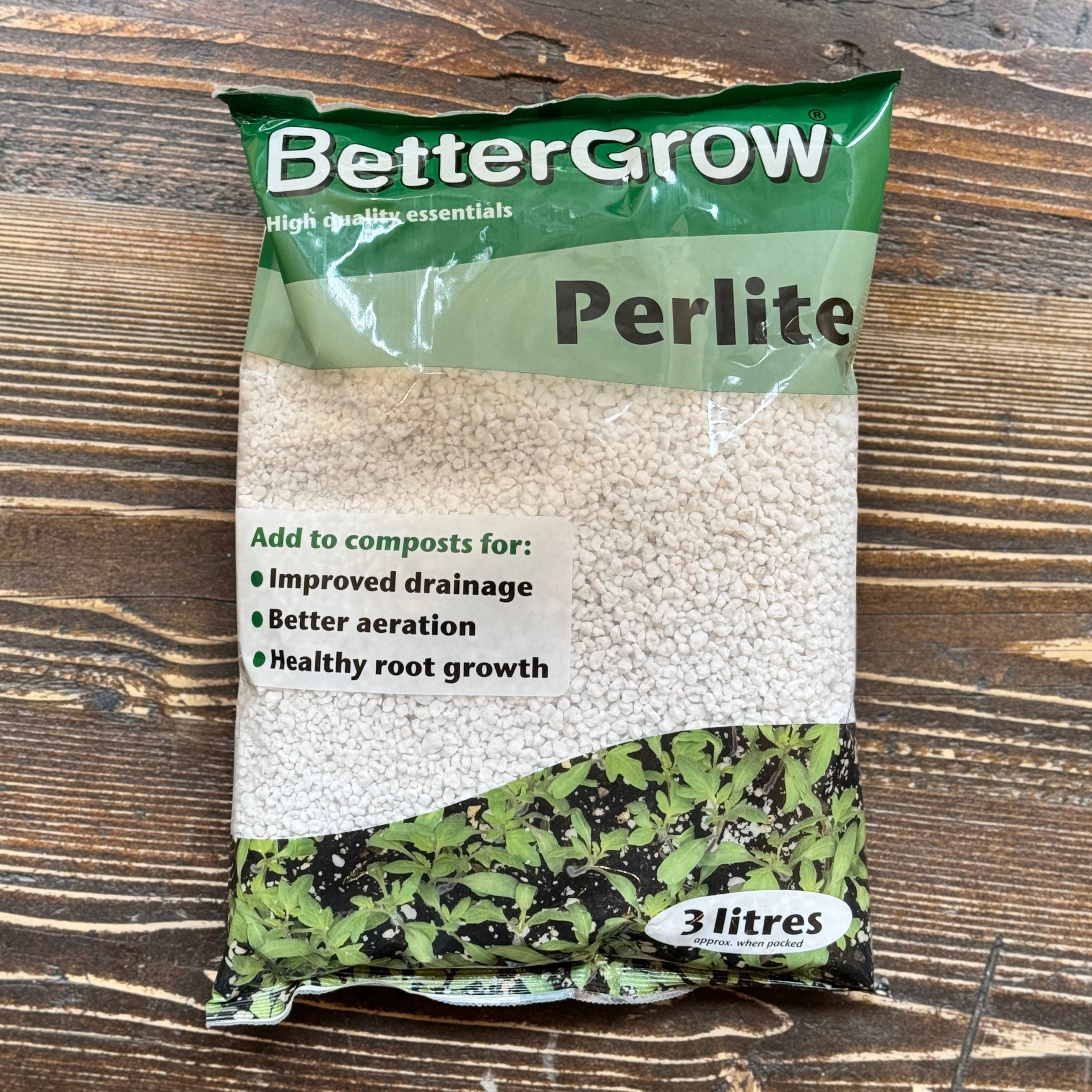 A 3 litres bag of BetterGrow Perlite on a dark wood background. The packaging features a green top section with white branding, a clear middle section showing the white perlite granules, and a green and black patterned bottom section.