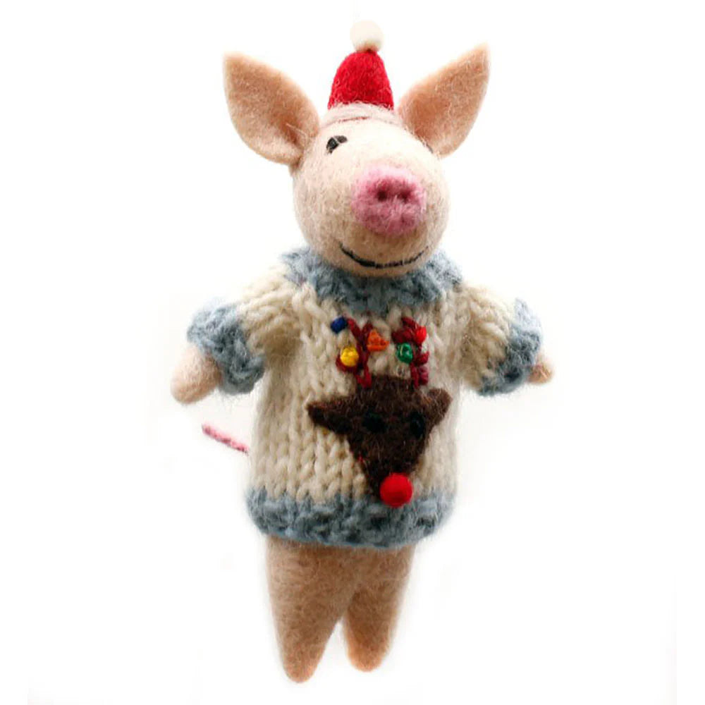 Toy pig wearing a knitted sweater with a reindeer design on a white background