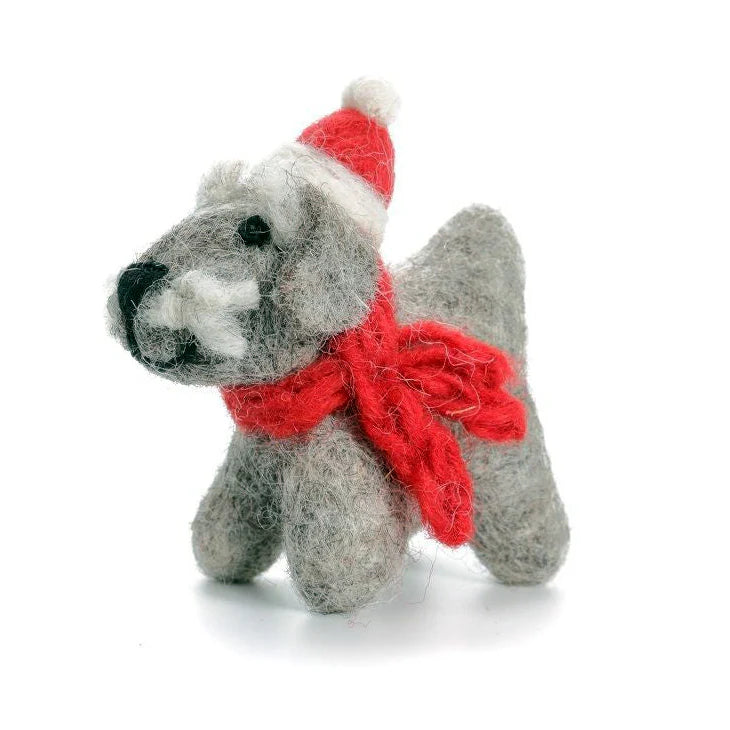 Small grey Schnauzer dog figurine wearing a red scarf and Santa hat on a white background