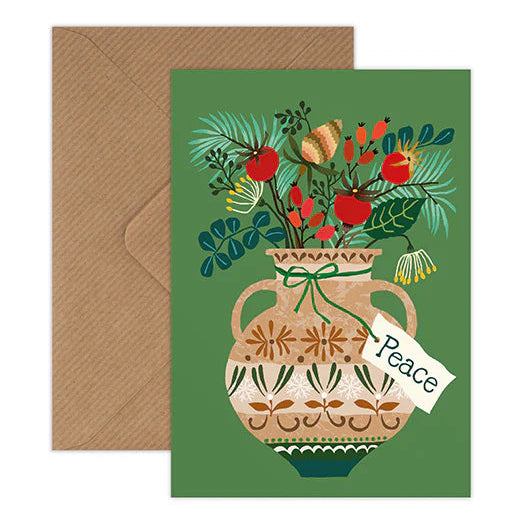 A square greeting card with a brown envelope behind it, featuring a green background and an illustration of a patterned vase filled with tropical flowers and fruit. A small tag on the card says 'Peace'.