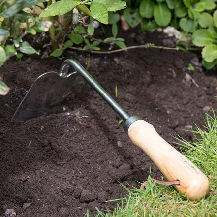 Burgon & Ball Hand Hoe with wooden handle in garden soil