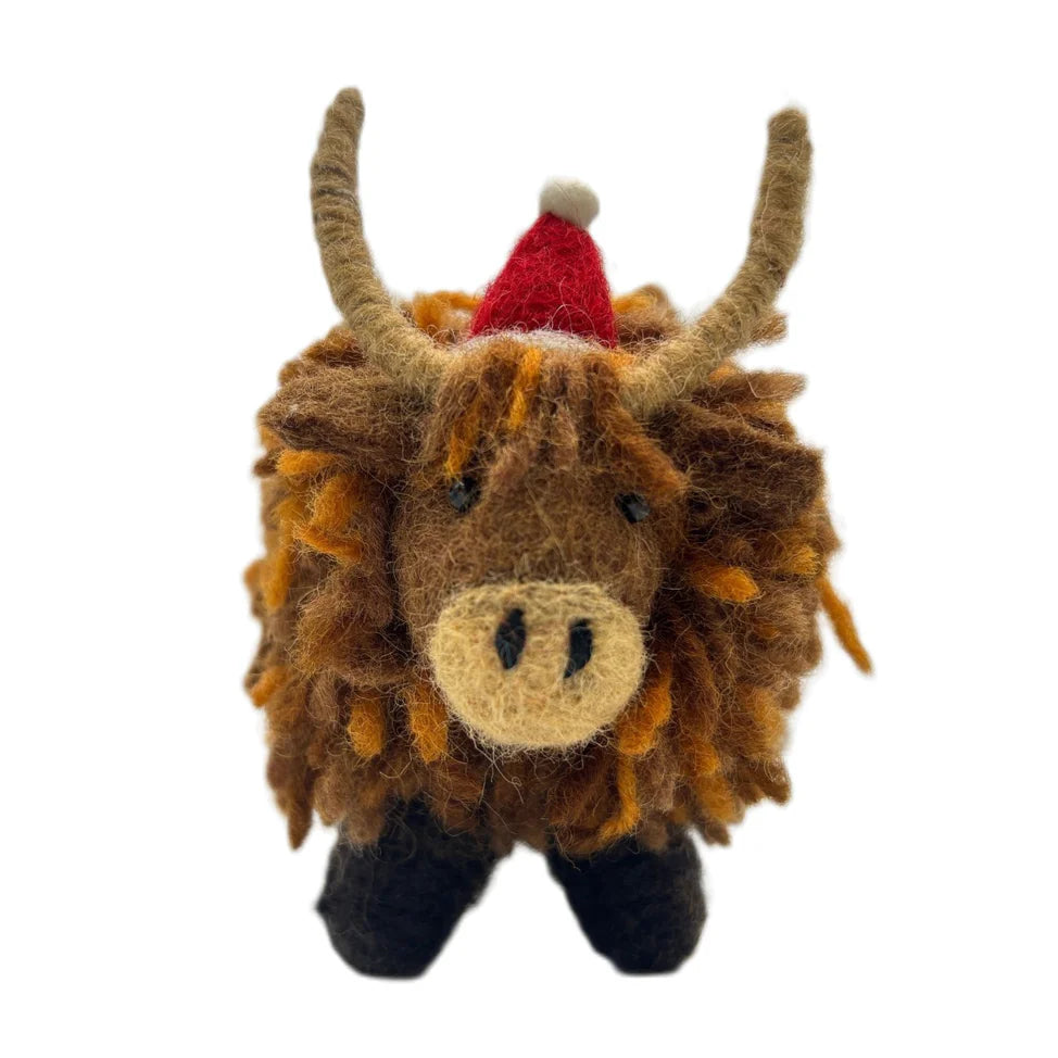Plush toy of a highland cow with a Santa hat on a white background
