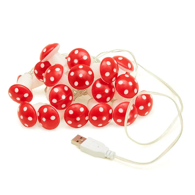 Red mushroom-shaped string lights with white polka dots and USB cable on a white background