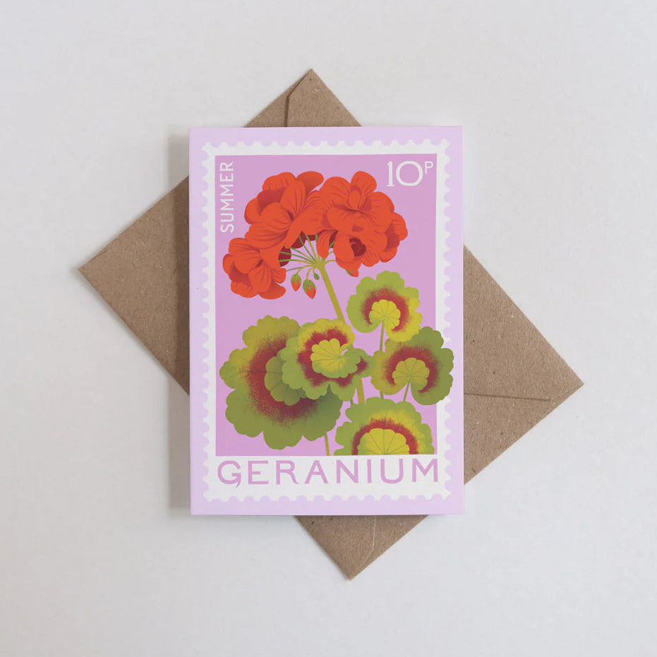 Card with geranium design and brown envelope on light gray background