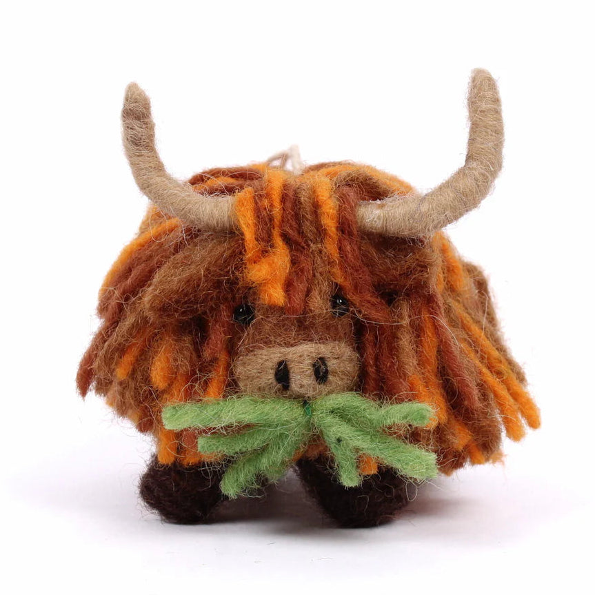 Felted toy highland cow with long hair and horns on a white background