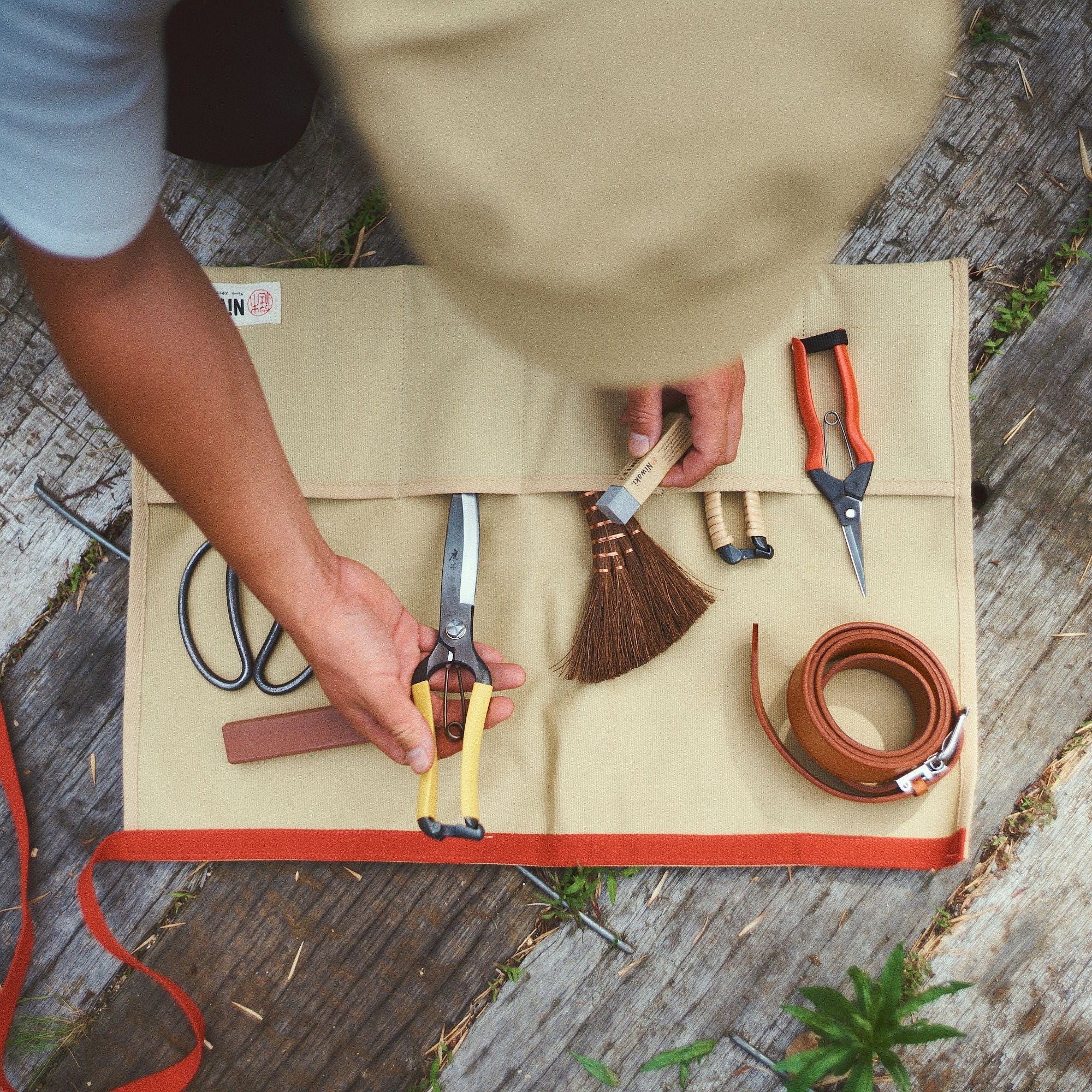 Person organizing tools on a wooden surface